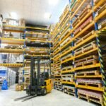 Industrial warehouse yard with forklift and stacked stock