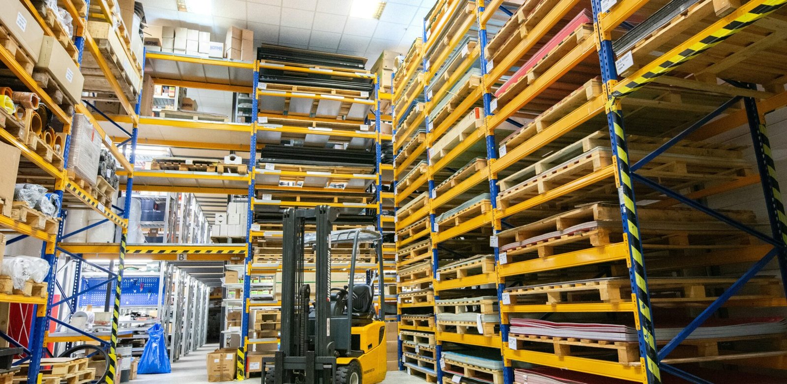 Industrial warehouse yard with forklift and stacked stock